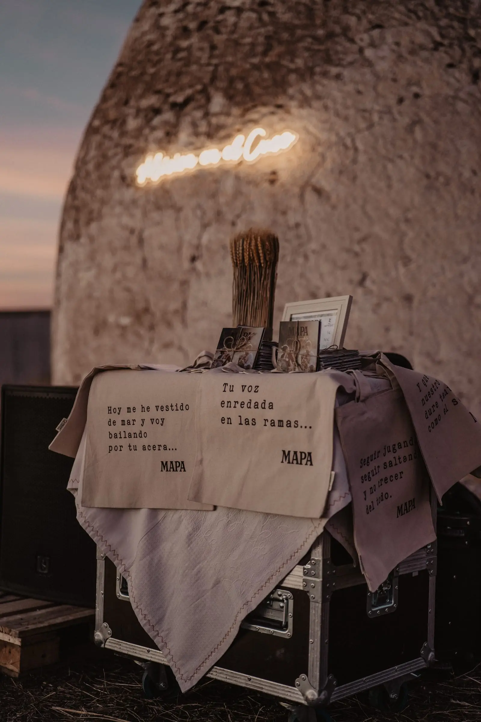 Mesa con letras de canciones de MAPA junto al neón del cuco