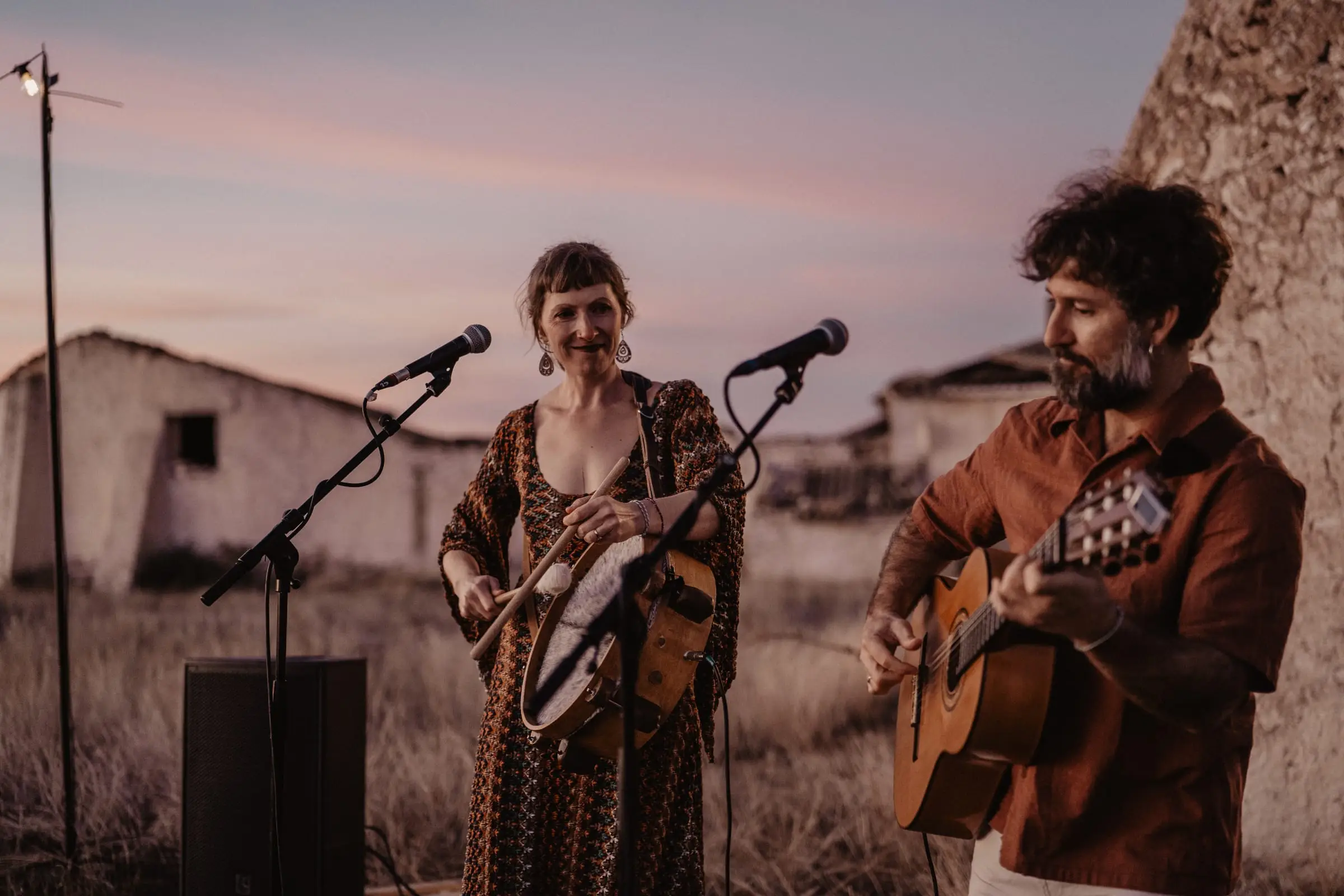 MAPA toca pandero y guitarra junto al cuco bajo un cielo rosado